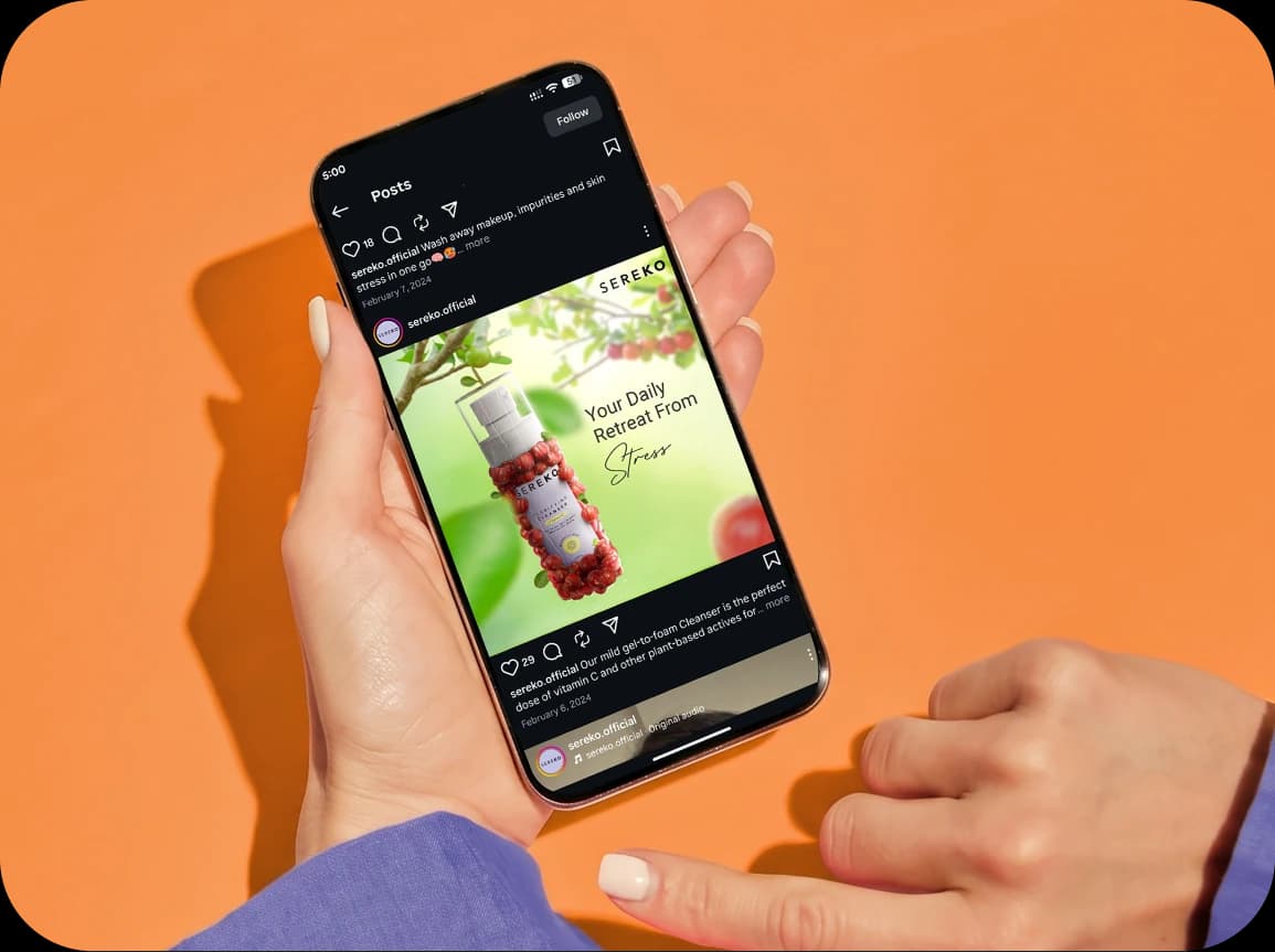 Sereko “Your Daily Retreat From Stress” Instagram post open on a phone held over an orange backdrop